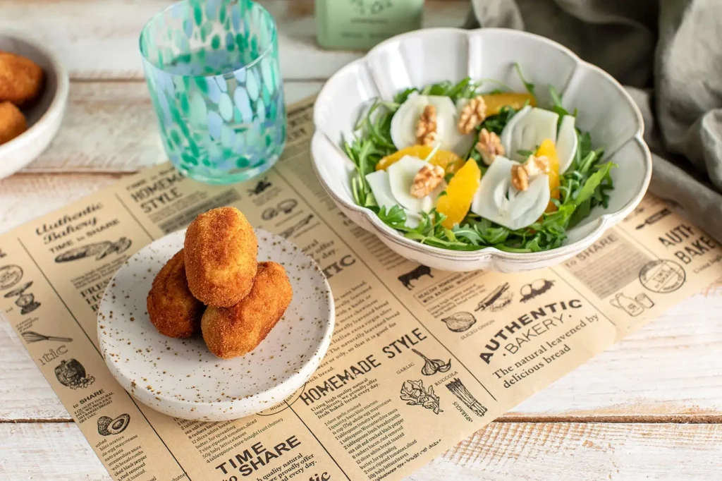 Croquetas caseras saludables acompañadas de ensalada con naranja y nueces