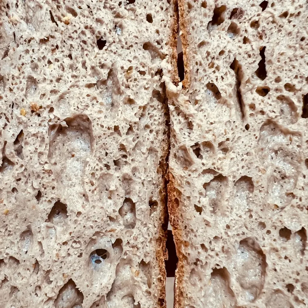 Miga de pan sin gluten esponjosa y aireada con grandes alveolos, demostrando la textura lograda con el curso de Lucía Gómez.